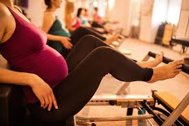 Pregnant woman exercising on a Reformer
